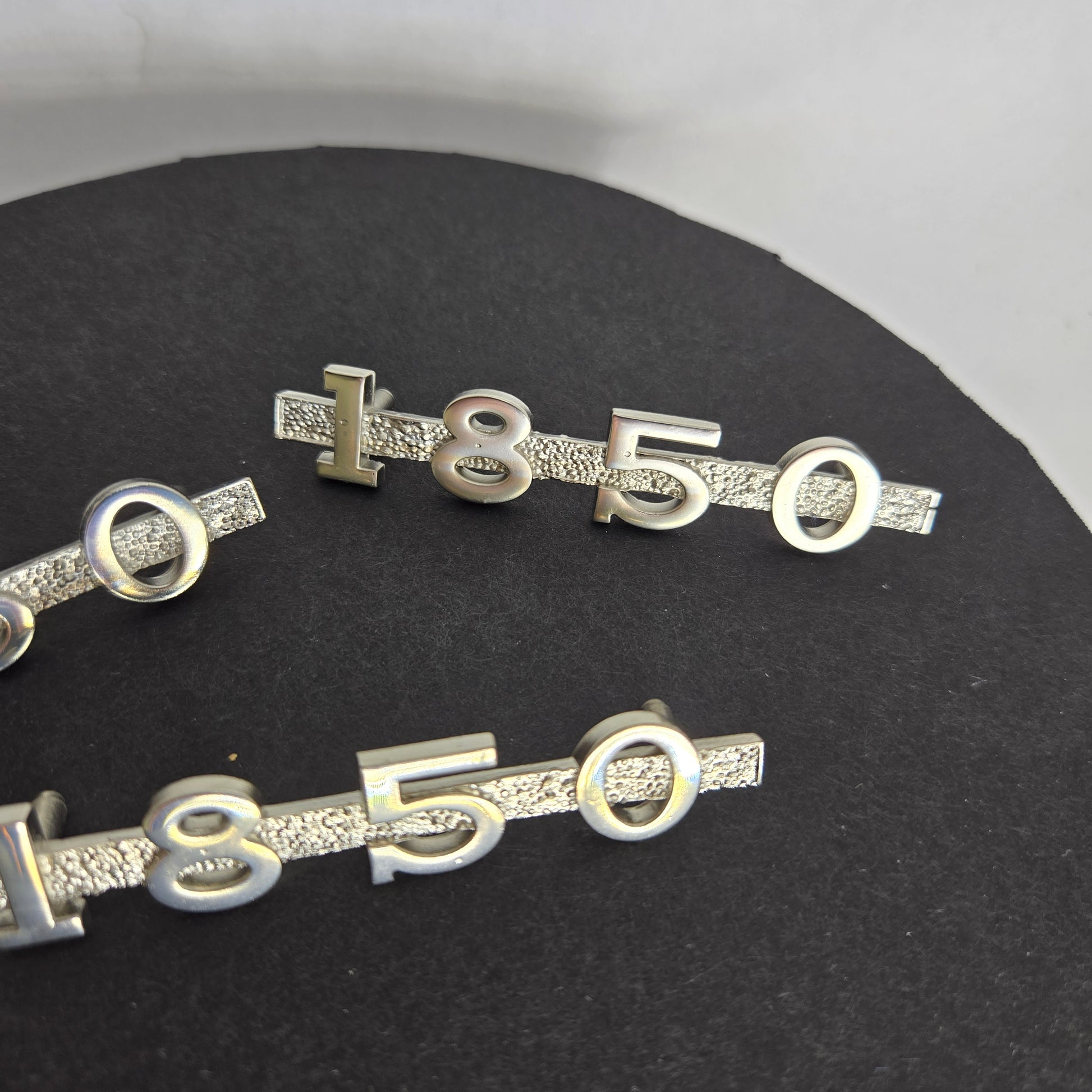 Different view of MGA 1850 emblem set on black disc with white background, highlighting accurate proportions and factory‑style detailing.