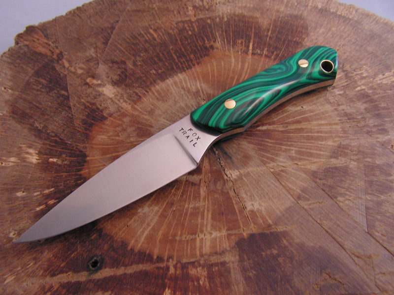Stainless steel neck knife with a synthetic malachite handle and Fox Trail maker’s mark, displayed on a wooden surface.