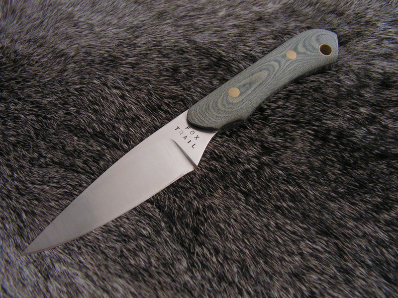 Neck knife with A2 steel blade and sandblasted wood handle featuring Fox Trail Craftworks maker’s mark, displayed on fur background.