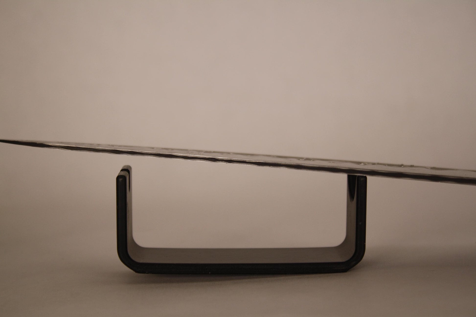 Macro shot of San‑Mai kitchen knife cutting edge, highlighting razor‑sharp 1095 high carbon steel core centered between contrasting nickel and stainless layers.