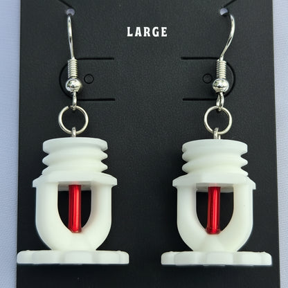 Pair of white fire sprinkler earrings with red frangible bulb on a black card labeled 'LARGE'.